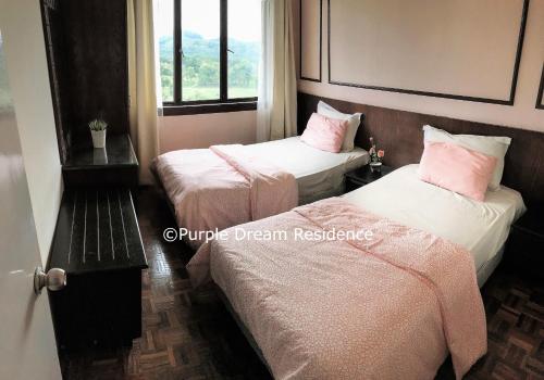 2 camas en una habitación de hotel con almohadas rosas en AFamosa Purple Dream Residence Condotel homestay en Melaka