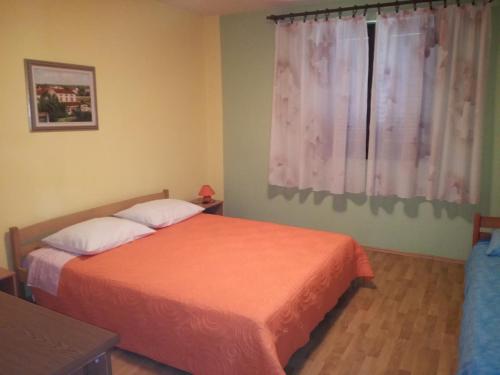 een slaapkamer met 2 bedden en een raam bij Apartment Nela in Funtana