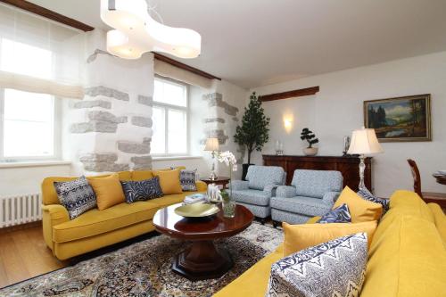 a living room with a yellow couch and a table at Tallinn City Apartments Old Town Toompea in Tallinn