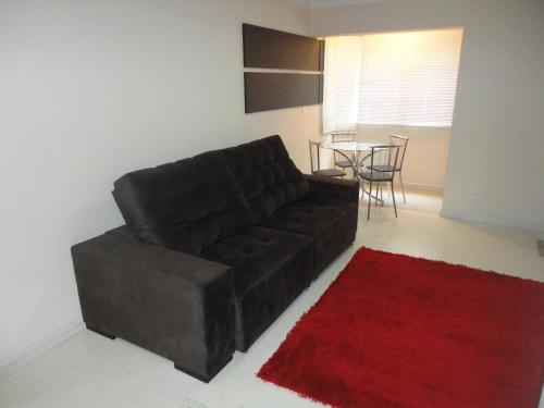 a living room with a brown couch and a red rug at Apartamento Baviera in Canela