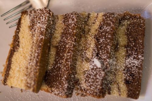 a piece of cake on a plate with a fork at Beatus Suites And Rooms B&B in Canicattì