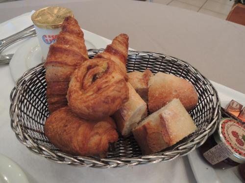 ein Korb mit Gebäck und Brot auf dem Tisch in der Unterkunft Hôtel 4C in Cluses