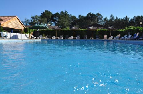 une grande piscine avec de l'eau bleue et des chaises dans l'établissement 