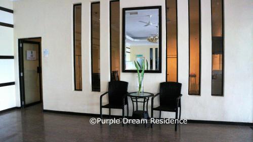 a table with two chairs and a vase on it at AFamosa Purple Dream Residence Condotel homestay in Melaka