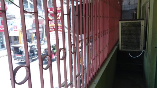a red wall with a gate next to a street at City Hotel in Allahābād