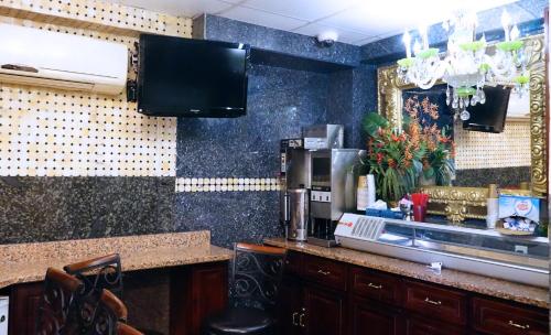 - une cuisine avec un comptoir et une cafetière dans l'établissement Paris Suites Hotel, à Queens