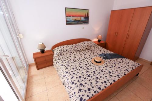 ein Schlafzimmer mit einem Bett mit Hut darauf in der Unterkunft Apartments Gabrijela - Villa Komarna in Klek