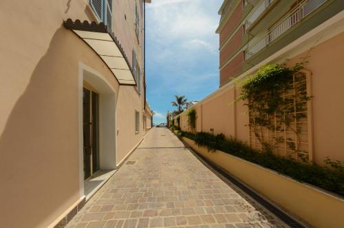 an empty alleyway between buildings in a city at Hotel De La Plage in Pietra Ligure