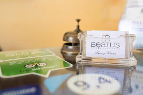 a table with a glass container with a bottle of bemis cosmetics at Beatus Suites And Rooms B&B in Canicattì