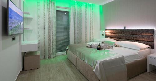 1 dormitorio con 1 cama grande con iluminación verde en Apartments The Seasons Residence en Omiš