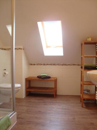 a bathroom with a toilet and a sink and a skylight at Gästehof - Weinbau Säger in Nordheim