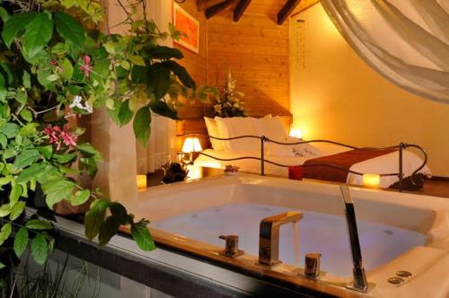 e bagno con vasca e rubinetto. di Talia Cabin Guest & Spa a Rosh Pinna