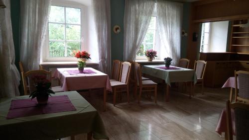 a dining room with two tables and two windows at Kloesterle in Bad Steben