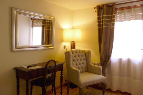 Habitación con escritorio, silla y lámpara. en Hostal Vidaller en Bielsa