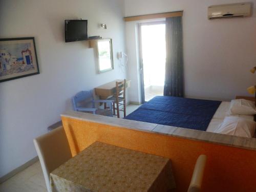 a bedroom with a bed and a dining room with a table at Paraschos Studios Kos in Kardamaina