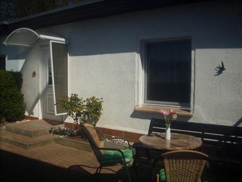 Un patio con una mesa y sillas y una ventana. en Bungalow Bansin, en Bansin