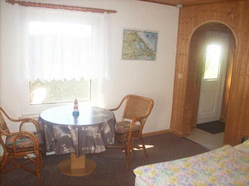 Zimmer mit einem Tisch, Stühlen und einem Fenster in der Unterkunft Bungalow Bansin in Bansin