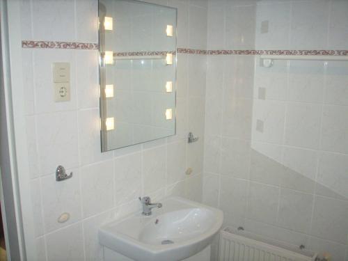 ein weißes Badezimmer mit einem Waschbecken und einem Spiegel in der Unterkunft Bungalow Bansin in Bansin