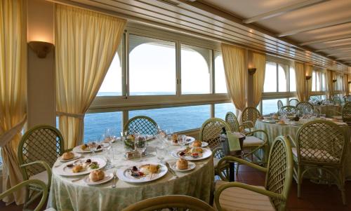 a dining car on a train with tables and chairs at Grand Hotel Baia Verde in Catania
