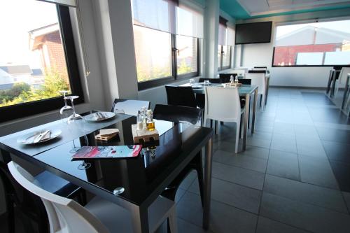 a dining room with tables and chairs and windows at Calas De Liencres in Liencres