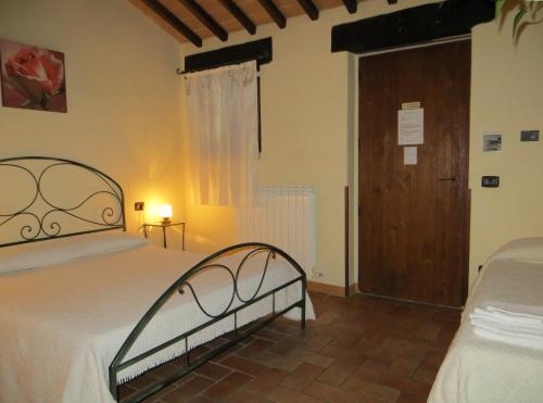 a bedroom with a bed and a wooden door at Agriturismo Casale delle Lucrezie in Todi