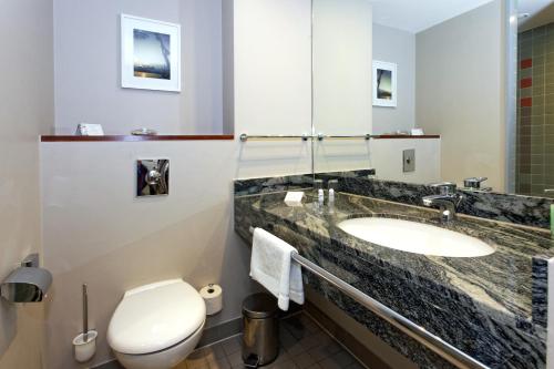 a bathroom with a sink and a toilet at Hotel Kaliebe in Trassenheide