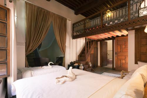 a bedroom with two beds with white cats on them at Riad Zanzibar in Marrakech
