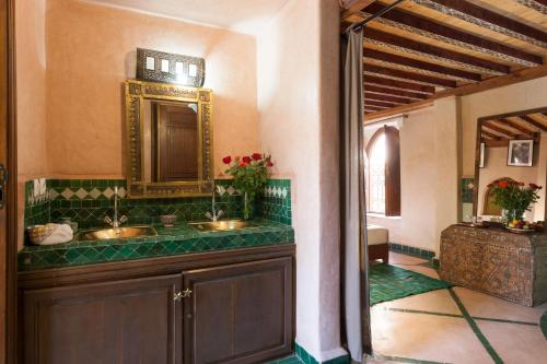 uma casa de banho com 2 lavatórios e um espelho em Riad Zanzibar em Marrakech