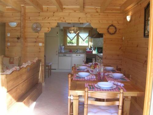 a wooden kitchen with a table and chairs in a cabin at Chalet Les Ecureuils in Saint-Nabord