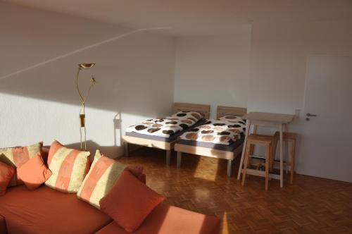 duas camas num quarto com um sofá e uma mesa em Ferienwohnung Weitblick em Velbert