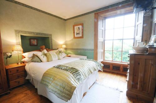 a bedroom with a large bed and a window at Stirabout Lane B&B in Rathdrum