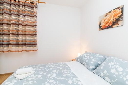 a bedroom with a bed and a window at Apartment Red Rose in Kaštela