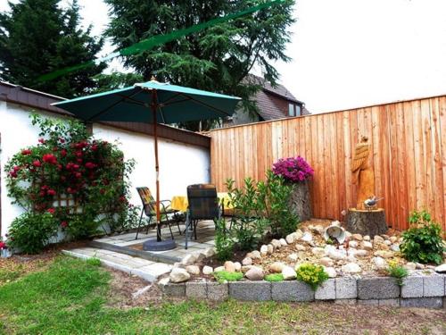 a patio with an umbrella and a table and chairs at Am-Immenweg in Bad Fallingbostel