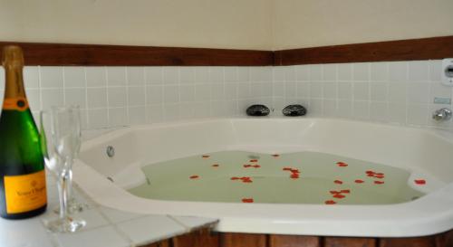a white bath tub with flower petals on the floor at Pousada Ilha Brazil in Ilhabela