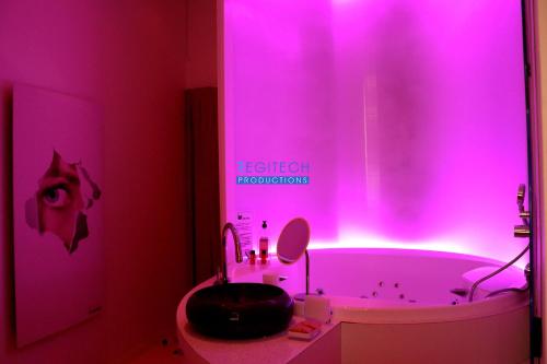 Baño de color rosa con bañera y lavamanos en Le Secret des Templiers, en Lyon