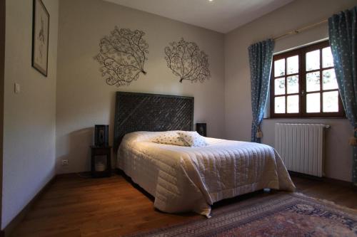une chambre avec un lit et une grande fenêtre dans l'établissement A L'orée Des Cévennes, à Aigremont