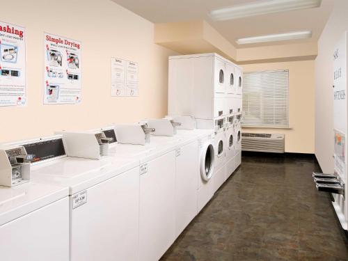 a white laundry room with a washer and dryer at WoodSpring Suites Kansas City Lenexa in Lenexa