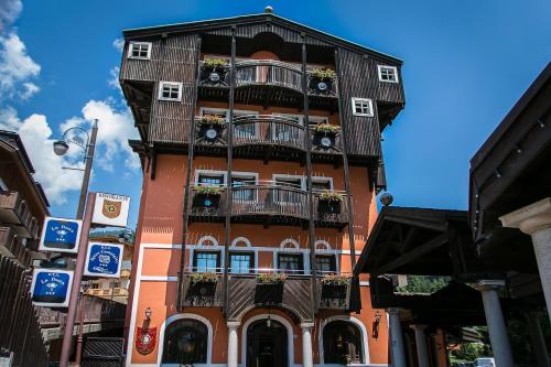 a tall building with balconies and flowers on it at Hotel Posta R.T.A. in Madonna di Campiglio