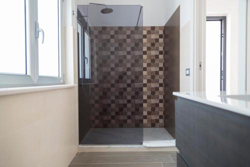 a bathroom with a shower with a tile wall at Santo Stefano Club in Praia a Mare