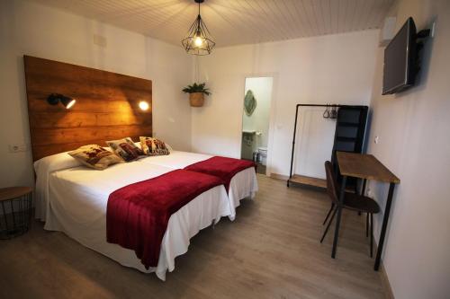 a bedroom with a large bed with a red blanket at Las Casitas in Santander