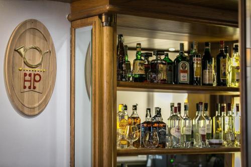 a bar with many bottles of alcohol on shelves at Hotel Posta R.T.A. in Madonna di Campiglio