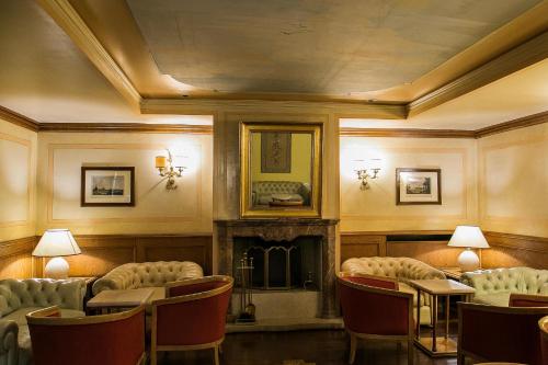 a room with a fireplace and chairs and a fire place at Hotel Posta R.T.A. in Madonna di Campiglio