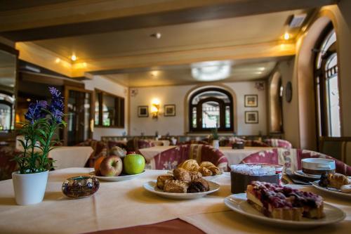 a table with plates of food on it in a restaurant at Hotel Posta R.T.A. in Madonna di Campiglio