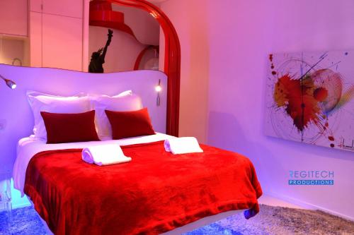 Un dormitorio con una cama roja y blanca con una manta roja en Le Secret des Templiers en Lyon