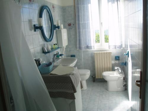 Albavillaにあるcasa vacanze La Casettaの白いバスルーム(洗面台、トイレ付)