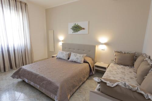 a bedroom with a bed and a couch at Innsud in Nardò