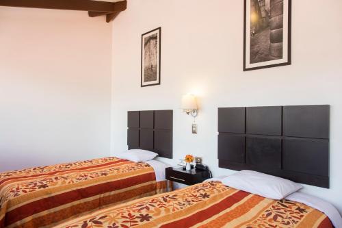 Postel nebo postele na pokoji v ubytování Hostal & Apartments El Triunfo