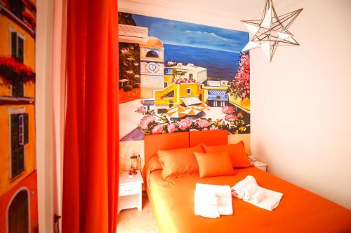 a bedroom with an orange bed with a painting on the wall at NapoliMia Boutique Hotel in Naples