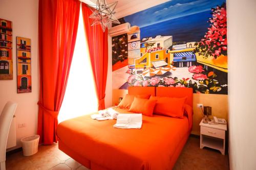 a bedroom with an orange bed with a painting on the wall at NapoliMia Boutique Hotel in Naples