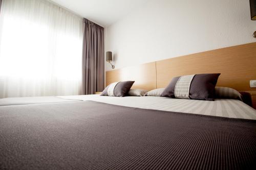 a bedroom with a large bed and a window at Aparthotel Acuazul in Peñíscola